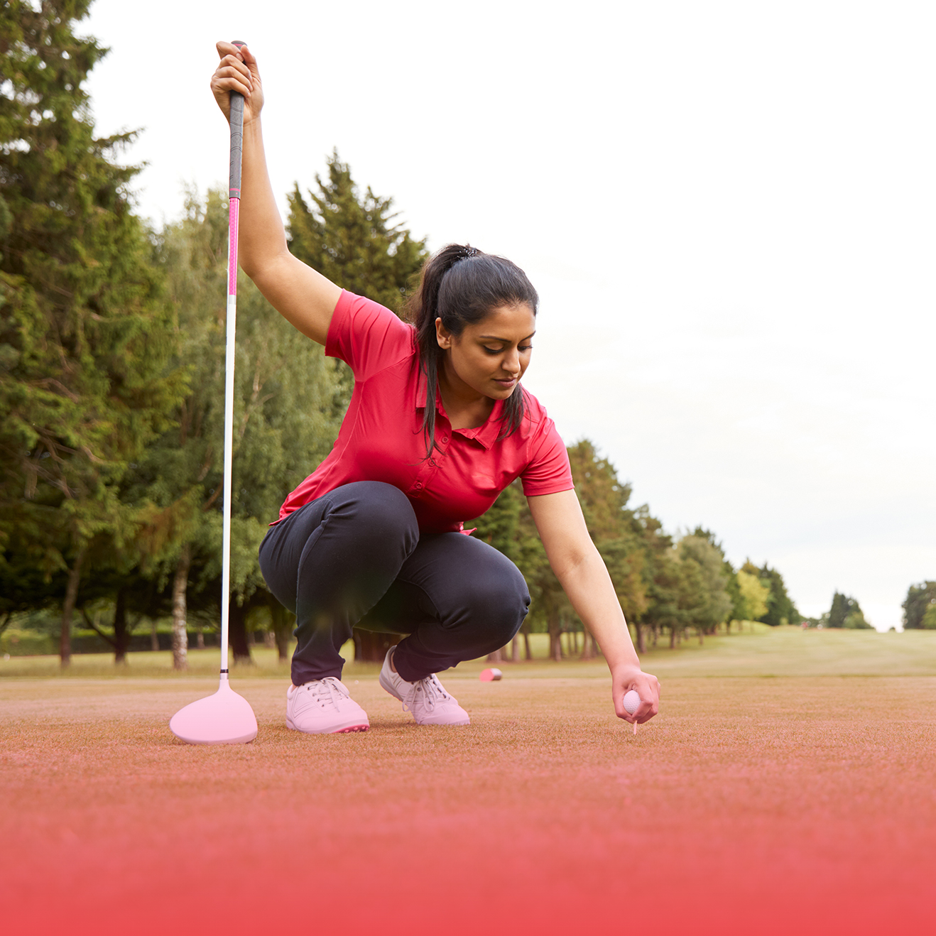 Woman teeing up golf ball
